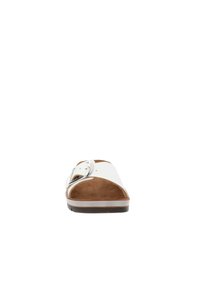 Sandalo bianco con una fascia larga e un'apertura accentuata da una fibbia argentata. Suola interna in suede marrone e suola in gomma bianca a contrasto.