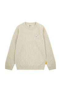 Beige Strickpullover mit Rundhalsausschnitt, langen Ärmeln und einem kleinen Bären-Patch auf der Brust. Enthält ein gelbes Markenschild an der Seite.
