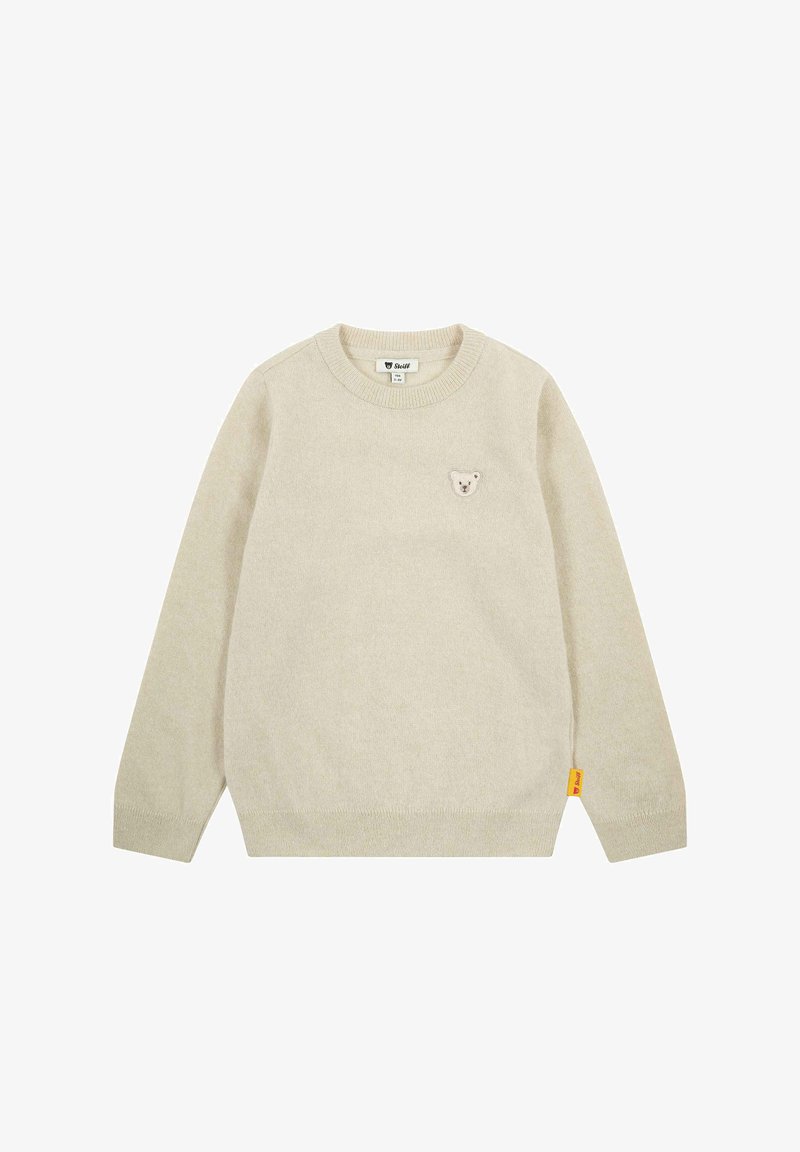 Beige Strickpullover mit Rundhalsausschnitt, langen Ärmeln und einem kleinen Bären-Patch auf der Brust. Enthält ein gelbes Markenschild an der Seite.
