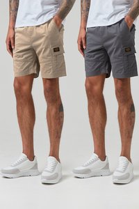 Beige und graue Cargoshorts aus Baumwolle, mit seitlichen Taschen und einem gewebten Etikett, kombiniert mit weißen Sneakers.