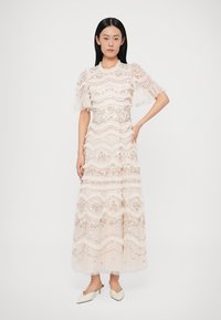 Dlhé svetloružové šaty s vrstvami volánov, kvetinovou výšivkou a krátkymi priesvitnými rukávmi. Majú priliehavý živôtik a splývavú sukňu.