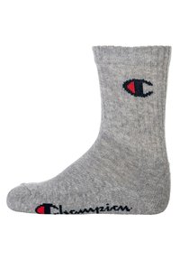 Calza di cotone grigia con texture a costine. Presenta un logo rosso e blu di lato e la parola "Champion" in nero lungo la caviglia.