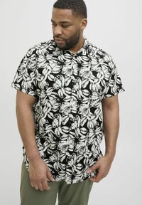 Schwarzes Kurzarmhemd mit einem weißen Blumenmuster, ausgestattet mit einem Kragen, einer Knopfleiste und einer lockeren Passform. Der Stoff wirkt leicht.
