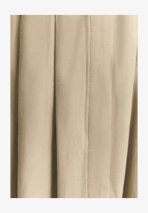 Bėgių audinys smėlio spalvos su tekstūruotu žuvies kaulo raštu. Turi aštrias klostes ir lygią apdailą. Sukurtas laisvai tekančiam, struktūruotam vaizdui.