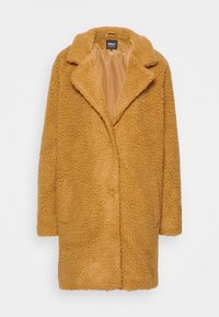 Żółty, teksturowany płaszcz o puszystej powierzchni, dużym kołnierzu i otwartym kroju z przodu. Podszewka wewnętrzna, długość do kolan, o luźnym fasonie.