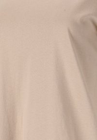Beige katoenen T-shirt met een zachte textuur, met een eenvoudig, ontspannen ontwerp zonder grafische elementen of opvallende details.