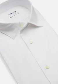Chemise blanche en tissu lisse, avec un col classique, des boutons blancs et une étiquette portant la mention "BOGGI MILANO BTECH."