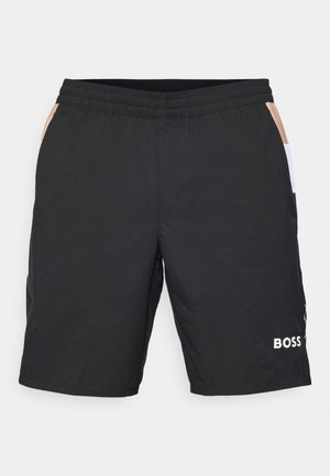 Pantaloni sportivi neri realizzati in materiale leggero, con vita piatta, tasche laterali e pannelli accentati beige e bianchi discreti.