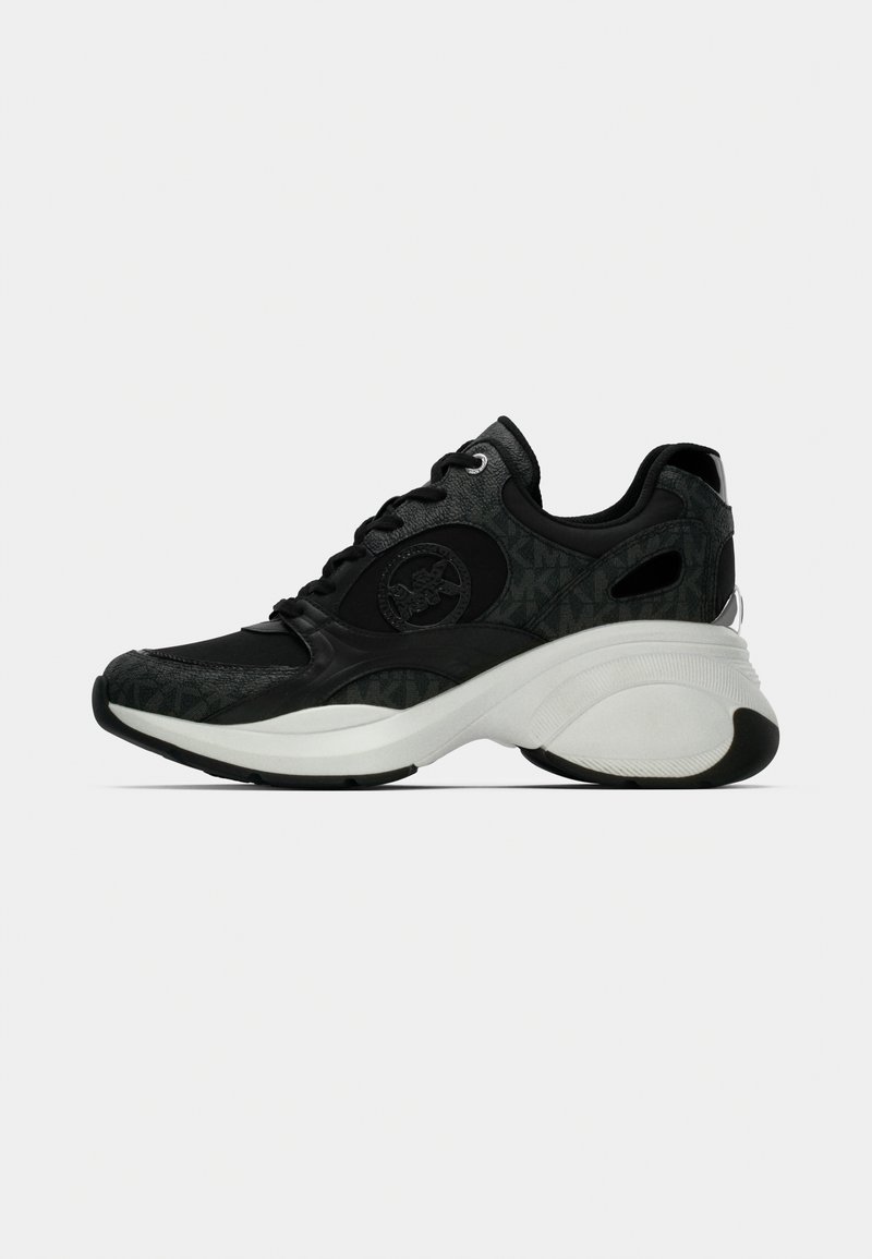 Μαύρο αθλητικό παπούτσι με διακοσμητικό επάνω μέρος, παχύ λευκό ενδιάμεσο πέλμα και υφασμάτινες λεπτομέρειες. Περιλαμβάνει κορδόνια και λογότυπο στο πλάι.