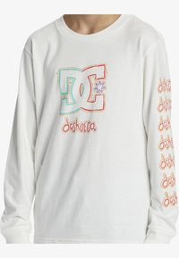 Langärmliges weißes T-Shirt aus Baumwolle, mit buntem DC-Logo und Markennamen-Graphics auf der Vorderseite und entlang des rechten Ärmels.