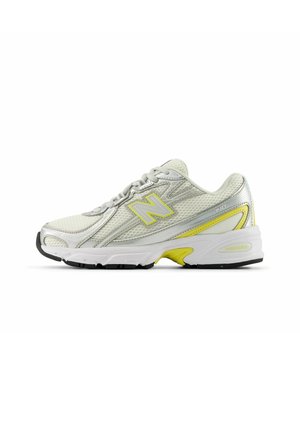 Chaussure de course blanche et argentée avec des accents jaunes, empeigne en mesh, design à lacets et semelle rembourrée avec la technologie ABZORB, vue de côté.