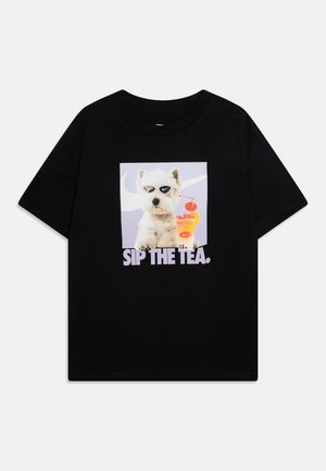 Juodas trumpas rankovinis marškinėlis, su grafika, kurioje pavaizduotas šuo saulės akiniuose su gėrimu, ir užrašu "GERK ARBATĄ." didelėmis raidėmis.