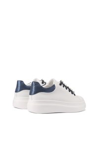 Sneaker bianchi in pelle con tacco in pelle verniciata blu navy, lacci decorativi e suola in gomma bianca.