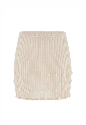 Beiger gestrickter Minirock mit gerippter Struktur und kleinen perlenähnlichen Perlen, die rund um die untere Hälfte angenäht sind.
