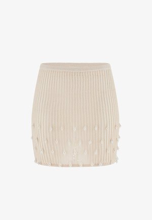 Mini-jupe tricotée beige avec une texture côtelée et de petites perles ressemblant à des perles cousues autour de la moitié inférieure.