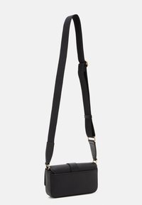 Bolso cruzado negro hecho de material estructurado, con un acabado suave, correa ajustable y detalles en tono dorado.