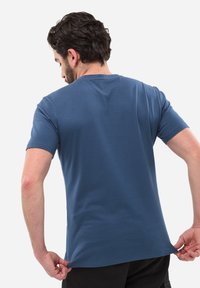 Koszulka z krótkim rękawem w ciemnoniebieskim kolorze, wykonana z bawełny, z okrągłym dekoltem i prostym dołem, o gładkiej fakturze i minimalistycznym wzornictwie.