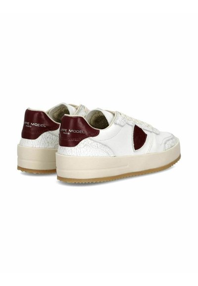 Hvide sneakers med en struktureret læderoverdel, burgunderfarvede accenter ved hælen og siden samt en tyk gummisål. Logo trykt på hælen.