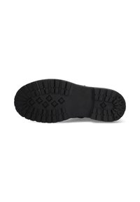 Suela de zapato de goma negra con un patrón de agarre texturizado y tacos decorados. Presenta secciones elevadas para una mejor tracción y estabilidad.