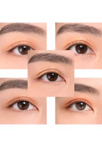 Nahaufnahme von braunen Augen mit sanftem orangefarbenem Lidschatten und subtilen Glitzer. Die Augenbrauen sind sorgsam geformt und texturiert, was die Details der Augen betont.