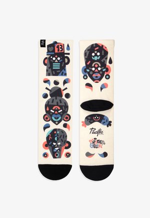 Skarpetki z kremowym tłem i kolorowymi, abstrakcyjnymi twarzami w kolorze czarnym, czerwonym, niebieskim i różowym. Czarne akcenty na palcach i pięcie, widoczne logo marki.