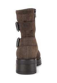 Bruine suède enkelboots met een platte zool, gekenmerkt door twee decoratieve gespen en een rits aan de zijkant voor sluiting. Glad oppervlak en stevige constructie.