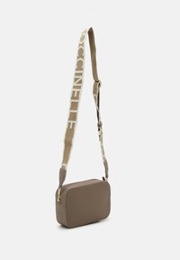 Sac bandoulière rectangulaire brun en matériau texturé. Il dispose d'une large sangle avec un logo et des accents en métal doré. Fermeture zippée.