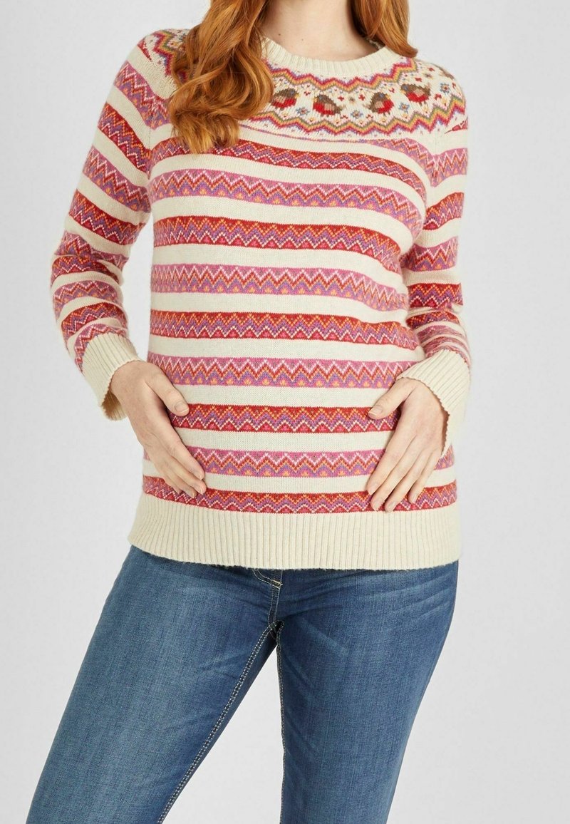 Pull en tricot avec une base crème ornée de motifs zigzag rouges, roses et orange. Encolure ronde et poignets et ourlet côtelés.