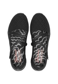 Černé dámské slip-on boty Skechers s pružnou síťovinou, paměťovou pěnou na stélkách a elastickými křížovými popruhy, z pohledu shora na bílém pozadí.