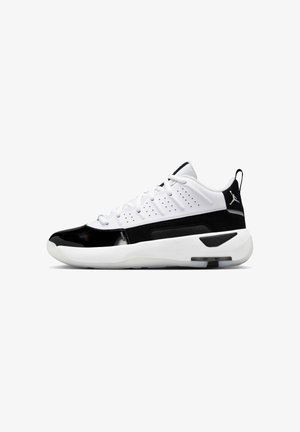 Weißes und schwarzes, niedriges sportliches Sneaker-Modell mit Schnürsenkeln, perforiertem Obermaterial, dicker Sohle und Air Jordan-Logo auf der Ferse, Seitenansicht.