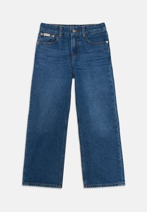 Jeans denim blu a gamba larga con chiusura a bottoni e cerniera, tasche frontali e una piccola etichetta Calvin Klein sulla tasca destra.