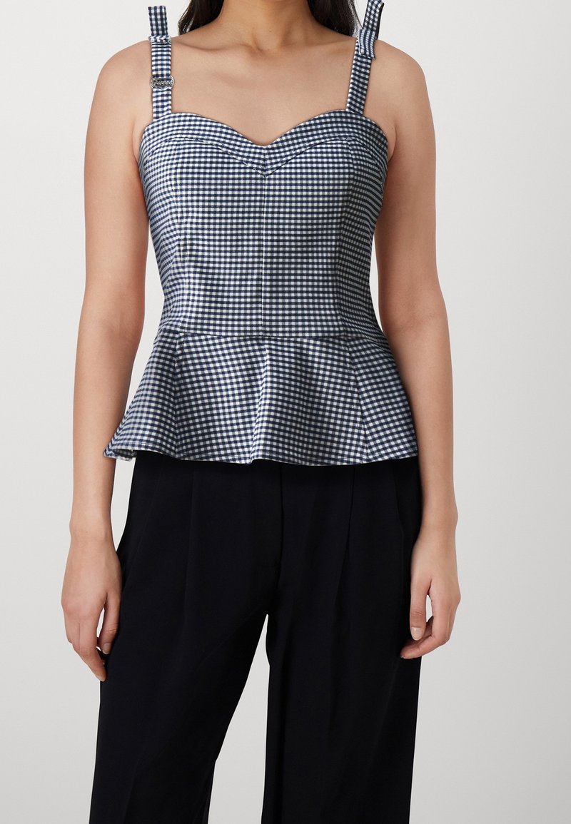 Top peplum en cuadros vichy azul marino y blanco, con tirantes ajustables y escote en forma de corazón. Tela suave y tejida con una forma estructurada.