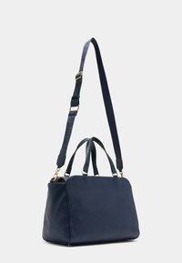 Borsa a mano in pelle azul navy con forma strutturata, doppi manici e tracolla removibile. Caratterizzata da dettagli in hardware dorato.