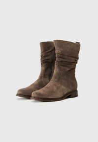Bottes de cheville en daim marron avec un design décontracté, bout arrondi et fermeture éclair sur le côté. Dotées d'un petit talon empilé et d'un dessus texturé.