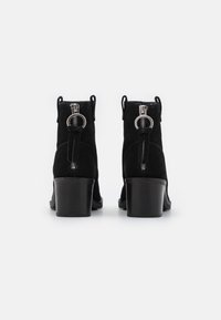 Svarta mocka ankle boots med avrundad tå, hög klack i blockform och dragkedjedetalj med en cirkulär accent på baksidan.