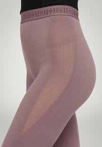 Hoghoogte leggings in lichtpaars, met een gemêleerd gaaspaneel en een elastische tailleband met logo-detail. Glad textiel afwerking.
