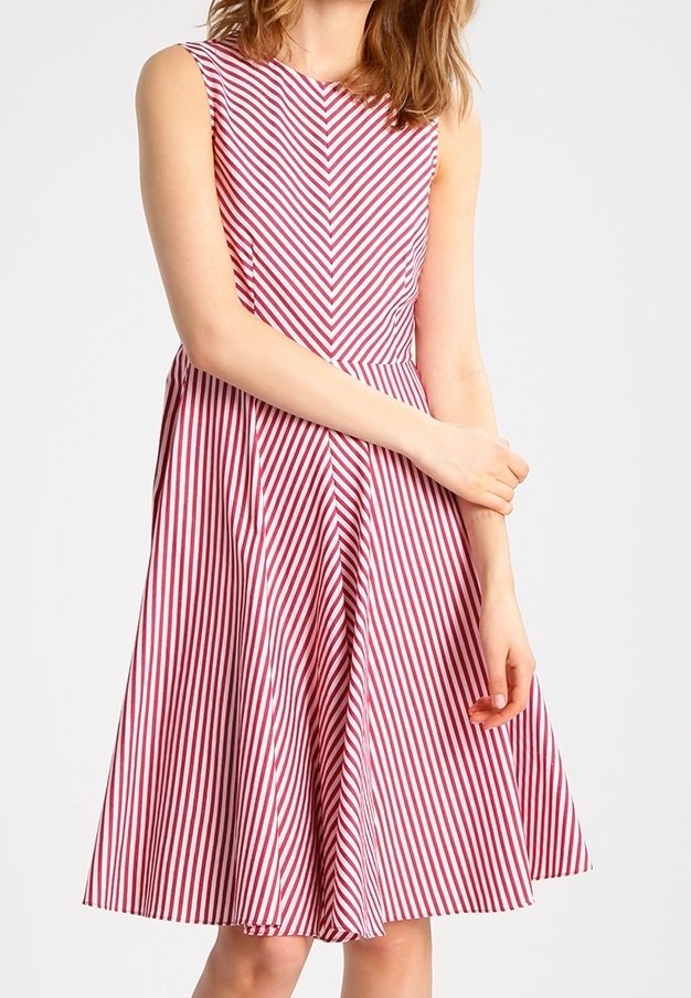 Robe sans manches à rayures rouges et blanches avec un corsage ajusté, une jupe évasée et un motif vertical créant un effet chevron.