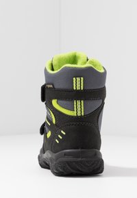 Botte de randonnée enfant noire et grise avec des accents vert néon et un col épais rembourré vue de dos.