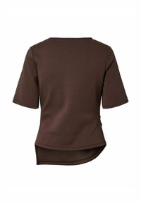 Top corto marrone a maniche corte con scollatura rotonda e orlo curvo, realizzato in tessuto morbido con una texture liscia. Design minimalista, senza motivi.