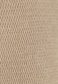 Beige dicht gewebter Stoff mit einem sich wiederholenden wellenförmigen Rippenmuster, das strukturierte horizontale Linien bildet.