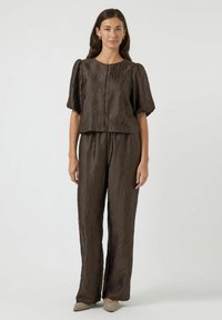 Brunt tekstureret to-delt sæt med puffærmer, der har et bølgemønster, lige benbukser og et cropped top design.