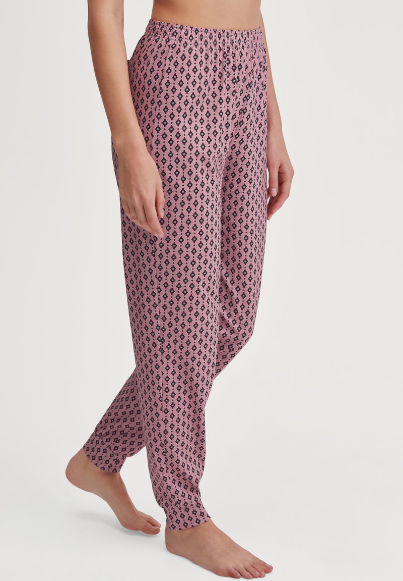 Lichte, roze pyjamabroek met een patroon van zwarte diamanten, elastische tailleband en tapered leg ontwerp. Zachte stoftextuur.