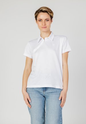Chemise polo blanche à manches courtes avec un col, dotée d'une patte de boutonnage et d'un petit logo sur la poitrine gauche. Texture de tissu lisse.