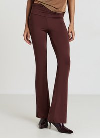 Bordeauxrote Schlaghosen mit einem breiten Bund, aus glattem, elastischem Material gefertigt. Eng geschnitten am Oberschenkel, verjüngend am Beinabschluss.