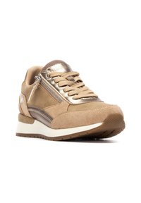 Zapatilla de gamuza marrón claro con acentos metálicos, cordones y un cierre lateral. Presenta una entresuela blanca y una suela de goma texturizada.