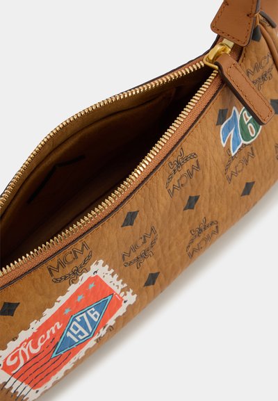 Ruskea nahkainen clutch-laukku, jossa on kultainen vetoketju, kohotetut MCM-logot ja värikäs 1976-grafiikka. Tasainen pinta ja litteä muotoilu.