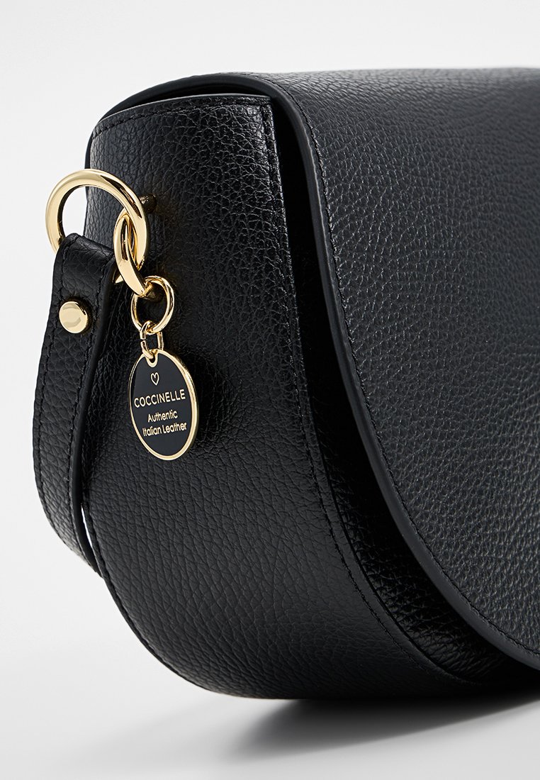 Schwarze Ledertasche mit einer genarbten Textur, runder Form, goldenen Beschlägen und einem Etikett mit der Aufschrift "Echtes italienisches Leder."