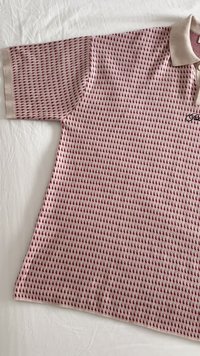 Kurzarm-Polohemd in Hellrosa mit einem strukturierten Muster aus kleinen kastanienbraunen Formen, ausgestattet mit einem weichen Kragen und gesticktem Logo.