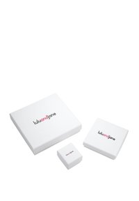 Bijele poklon kutije različitih veličina s "lulujane" logotipom u crnoj i ružičastoj boji; glatka površina, pravokutni i kvadratni oblici.