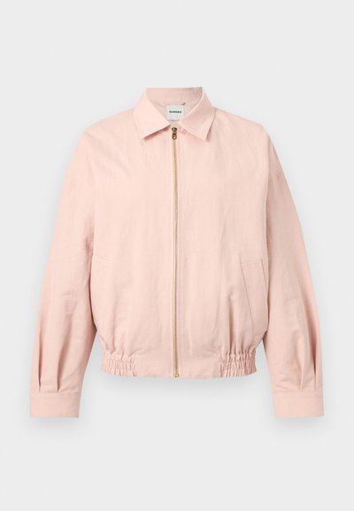 Ροζ ανοιχτόχρωμο μακρυμάνικο μπουφάν με φερμουάρ μπροστά, γιακά, ελαστική μέση και πλαϊνές τσέπες, παρουσιασμένο σε απλό φόντο.